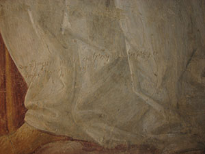 Iscrizione sulla veste di un angelo nella parete di fondo del tabernacolo della Madonna della Tosse.
