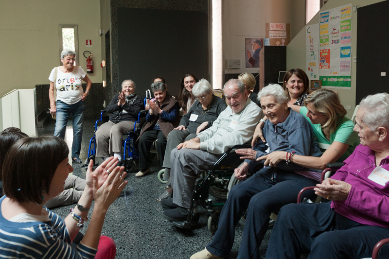 persone anziane e accompagnatori ridono durante una attività al museo