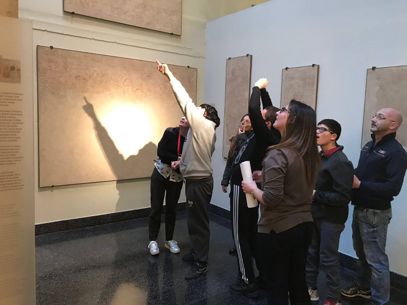 educatrici e ragazzi guardano gli affreschi durante una visita
