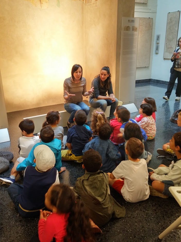 bambini ascoltano le educatrici durante la visita al museo