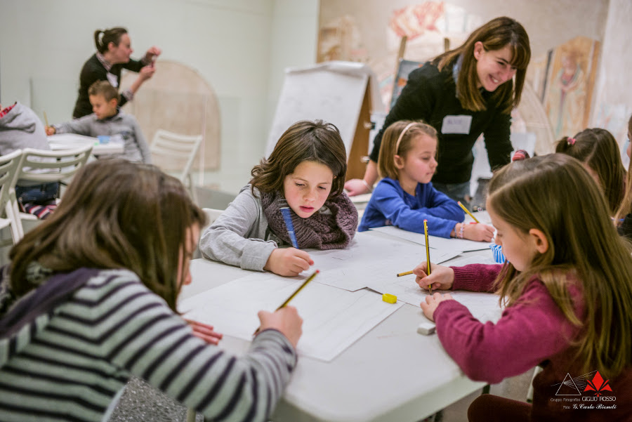 bambini disegnano concentrati nelle sale del museo